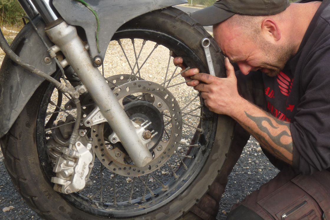 "Frank trying to fix his motorcycle"