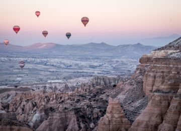 While staying at my 5 euro a night hostel in a cave in Goreme, I would wake up early every morning at the onset of winter, and ride out to the red rocks to watch the ballons rise at sunrise. It is everything they say it is.